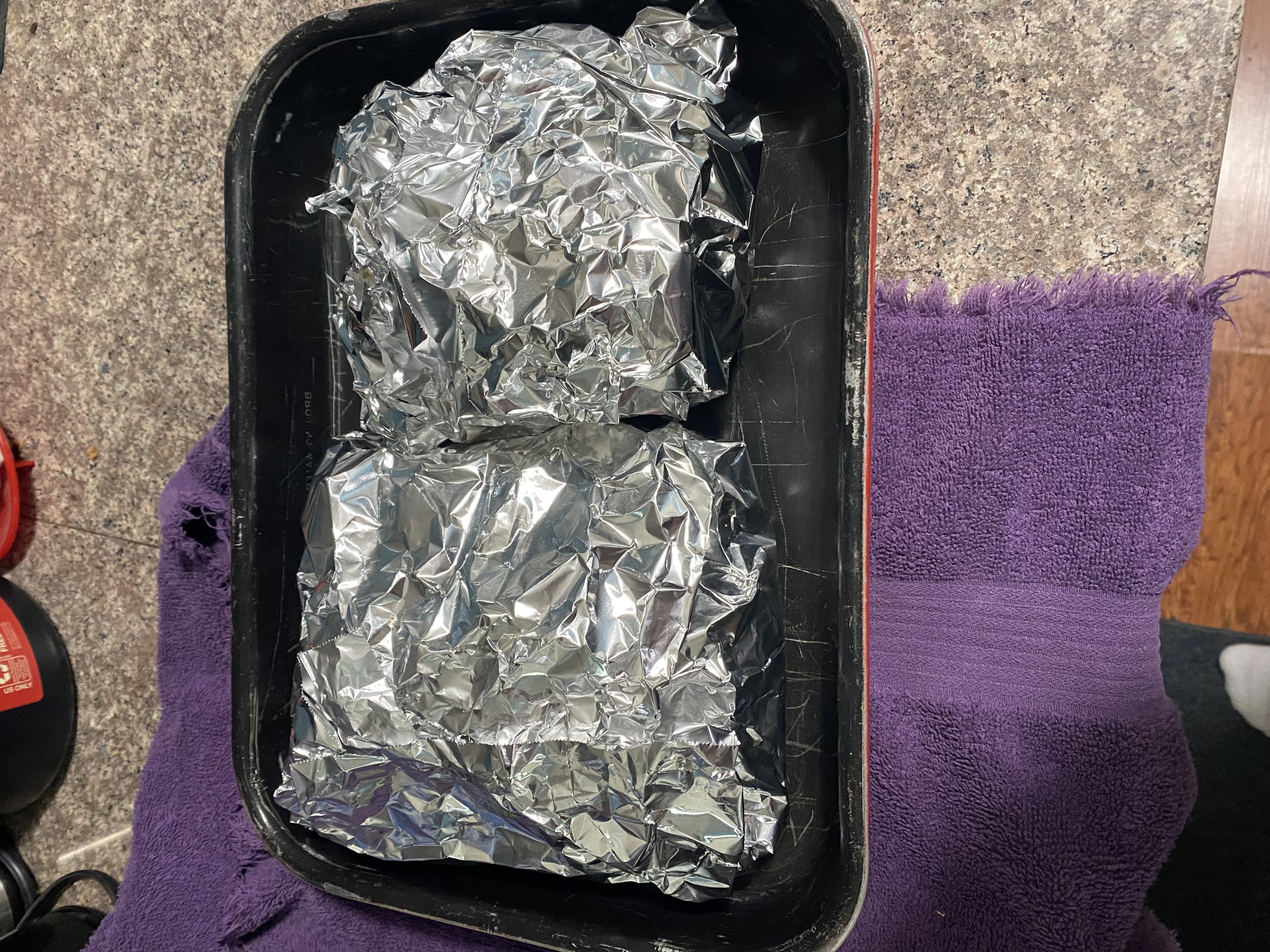 Ribs wrapped in foil, in a pan, ready for baking